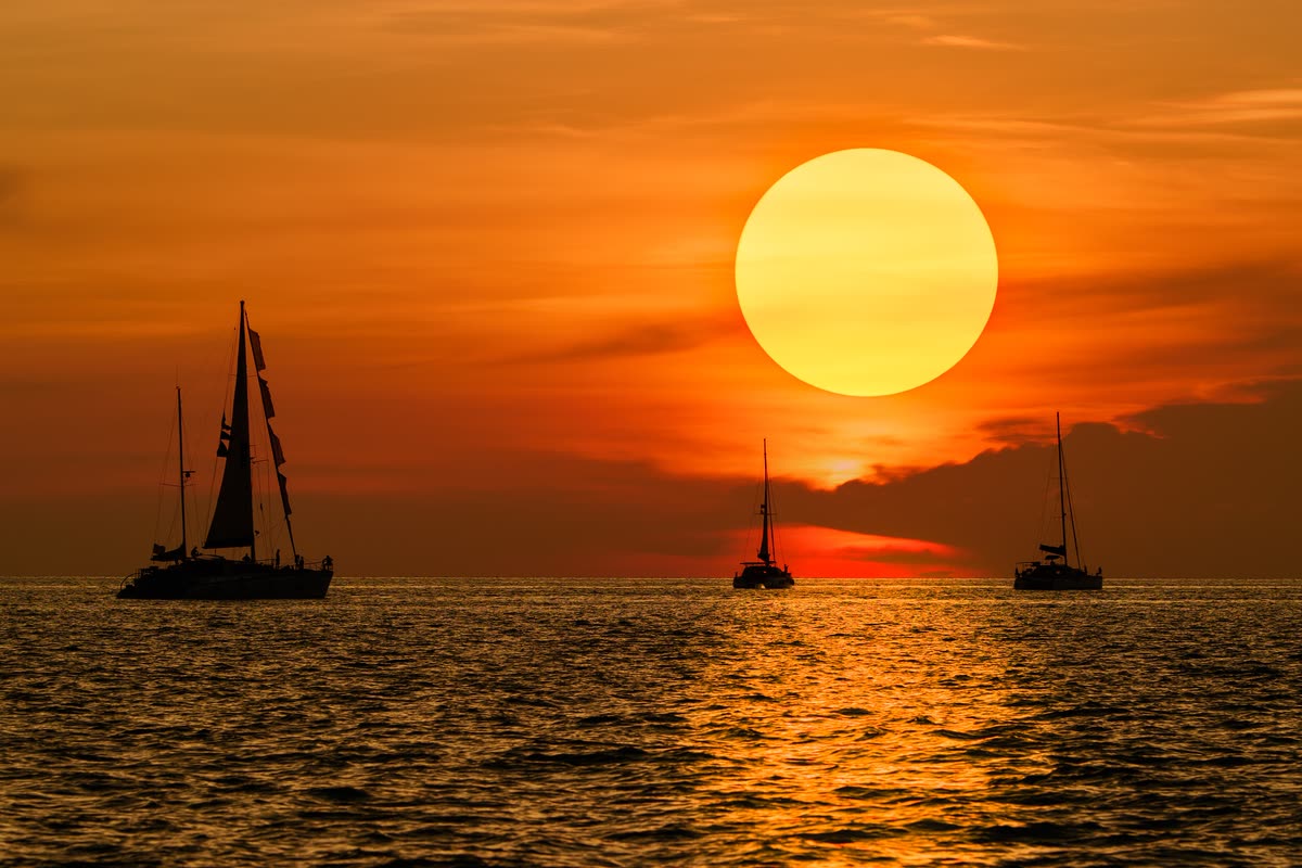 Veleros navegando al atardecer